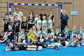 Licht und Schatten bei Handballern von Grün-Weiß Niederwiesa - Die E-Jugend des SV Grün-Weiß Niederwiesa (weiße Trikots) beim gemeinsamen Training mit dem Nachwuchs vom HC Elbflorenz in der Ballspielhalle Dresden. Steffen Funke (h. r.) und Simone Sättler-Gruhle (h., 2. v. l.).