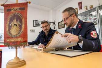 Lichtenau: Endlich optimale Bedingungen für Auerswalder Feuerwehr - Jörg Geyer und Robin Winkler (v. l.) sind die Feuerwehrchefs in Auerswalde. Gemeinsam studieren sie Unterlagen im Schulungsraum des neuen Gerätehauses.