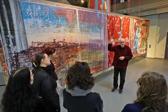 Lichtenstein: Als der „Teppichfritze“ in Ost-Berlin David Bowie traf - Ulrich Reimkasten mit Studentinnen aus Schneeberg vor dem Duplikat eines Teil seines Werkes „Luthers letzte Reise“: Das Original hängt in Eisleben und ist 32 Meter lang.