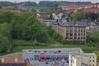 Lichtenstein: Esda-Brache nach Bränden wieder im Fokus - Der graue Fabrikkomplex erhebt sich oberhalb des Geländes mit Rewe- und Baumarkt und dominiert immer noch das Bild der Lichtensteiner Innenstadt.