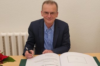 Lichtentanne: Historiker sorgt für „gläsernes“ Schönfels - Jörg Hofmann trägt sich ins Ehrenbuch der Gemeinde Lichtentanne ein.
