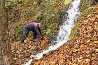 Lichtenwalde: Wenn Ritter Harras das Wasser laufen lässt - Wanderwegewart Rolf Pönicke am künstlichen Wasserfall. In den zurückliegenden Wochen wurde die Wasserrinne von Unrat befreit.