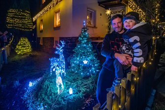 Lichtermeer im Flöhatal: Dieses Haus zwischen Pockau und Lengefeld zieht alle Blicke auf sich - Marcel Hunger, hier mit seinem Sohn Ryan, hat etwa zwei Wochen lang sein Haus samt Grundstück mit leuchtender Dekoration geschmückt.