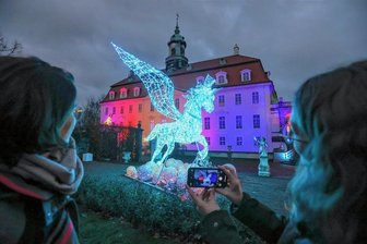 Lichterschau "Lumagica" in Lichtenwalde eröffnet - Jetzt leuchtet der Schlosspark - Das geflügelte Einhorn vor dem Barockschloss stellt die Verbindung her zwischen der Märchenschau "Sterntaler" und der regionalen Harras-Sage.