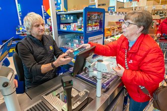 Lidl eröffnet neuen Markt in Olbernhau, auch für Marienberg gibt es Neuigkeiten - Bürgermeister Jörg Klaffenbach an der Lidl-Kasse. Monika Mock findet die Aktion gut.