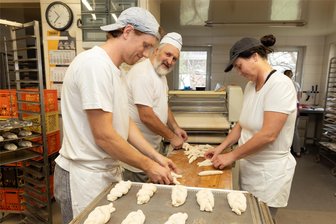 Lieblingsbäcker: Schon mehr als 3000 Erzgebirger haben ihre Stimme abgegeben - Besonders beliebt bei den Kunden vom Köhler-Bäck in Neudorf sind die Pfannkuchen und die Mohnzöpfe – im Bild der Sohn des Chefs, Nathanael Heymann, Bäckermeister Rolf Köhler und Caroline Schmidl beim Flechten der Mohnzöpfe.