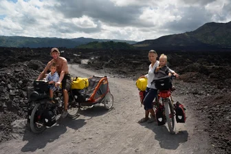 Livevortrag im Clubkino Glauchau: Weltreise mit Kindern auf Fahrrädern - Die vier Weltreisenden auf einem Lavafeld auf Bali.