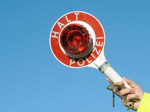 Lkw-Kontrollen: Knapp 60 Ordnungswidrigkeiten auf A4 - Ein Polizist hält eine Kelle.
