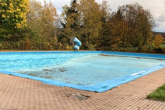 Löcher gestopft, aber jetzt gibt es neue Probleme: Wie ein Ort im Erzgebirge um sein Freibad kämpft - Über den Winter stand das Becken des Bockauer Freibads aufgrund von Bauarbeiten an einer Außenwand leer. Das verursachte neue Schäden.