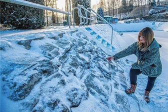 Löcherstopfen im Schwimmbecken: Aue investiert ins Freibad - Jeannie Guhde, die in der Stadt Aue-Bad Schlema für Freibad und Schwimmhalle zuständig ist, zeigt auf die aus Granitsteinen gemauerten Seitenwände. Dort wurden Löcher festgestellt.