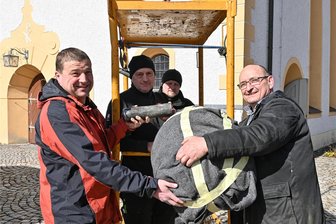 Luftiger Frühjahrsputz an Neudorfer Kirchturm - Uhr und Wetterhahn sind zurück - Bei der Übergabe der Bleihülse und der vergoldeten (hier noch verpackten) Turmkugel: René Weighardt vom Kirchenvorstand und Neudorfs Kirchner Bernd Fuhrmann (v. v. l.) sowie Uwe Nothnagel und Pattrick Krebs (h. v. l.) von der Thüringer Firma Willing.