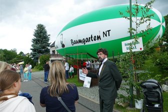 Luftschiff macht beim stehenden Festumzug in Borstendorf Station - Um Besuchern beim stehenden Festumzug die Geschichte von Georg Baumgarten zu erklären, schlüpfte Fritz Stengel vom Heimatverein Grüna in dessen Rolle. Sein Luftschiff hatte der „fliegende Oberförster“ natürlich dabei.