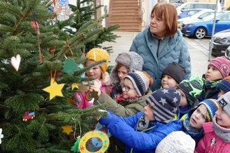 Märchenwald braucht neuen Schmuck - Zusammen mit Erzieherin Ramona Böhmer hängen Kinder der Kita Pfiffikus gebastelten Weihnachtsbaumschmuck vor dem Rathaus auf.