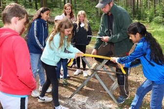Mädchen und Jungen gehen Waldarbeitern zur Hand - Waldjugendspiele im Leubnitzer Revier: An der Station von Christian Puffke mussten die Viertklässler der Grundschule Frankenhausen Geschick und Schnelligkeit beim Sägen beweisen.