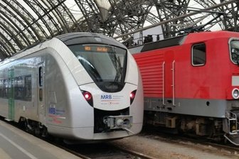 Mängel an nagelneuen Zügen: MRB streicht Fahrplan zusammen - Einer der neuen Alstom-Züge neben einer E-Lok der Baureihe 143. Die "Silberpfeile" machen derzeit Ärger.