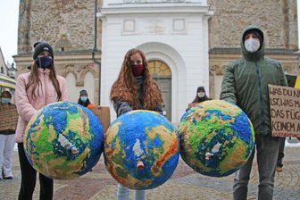 Sandra Weise, Chayenne Bohlinger und Lukas Häuser vom Bündnis "Freiberg klimaneutral" demonstrieren gemeinsam mit anderen vor der Nikolaikirche kurz vor der Sitzung des Freiberger Stadtrates.