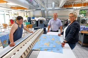 „Man bekommt viel mehr zurück, als man gibt“: Chefin des Lebenshilfewerkes Oberlungwitz geht in Ruhestand - Ute Gläß und ihr Nachfolger Roy Kämpf mit Konrad Simon in der Wäscherei des Lebenshilfewerkes.