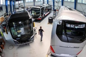 MAN kündigt Standortsicherung - Ein Mitarbeiter geht durch eine Halle mit Elektrobussen von MAN.