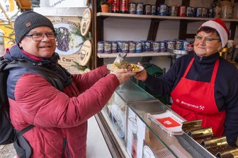 „Manche sagen auch Verkehrsunfall dazu“ – Auf Weihnachtsmarkt im Erzgebirge gibt es eine ganz spezielle Leckerei - Franko Schmidt aus Chemnitz ließ sich bei seinem Besuch auf dem Annaberger Weihnachtsmarkt die „Tote Oma“ nicht entgehen. Serviert wurde sie ihm von Ursula Ebert.