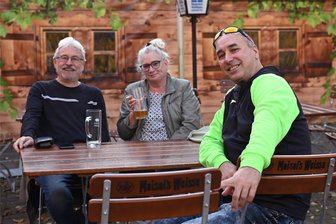 Manhattan-Ost in Rochsburg: In dieses Lokal ist der Sommer zurückgekehrt - Jürgen, Simone und Enrico (von links) hat es eher zufällig in den Biergarten Manhattan-Ost in Rochsburg verschlagen. Doch weil die drei begeistert waren, werden sie künftig wohl auch zum Glühwein-Büdchen kommen.