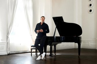 Marc Marshall wird im Stadttheater Glauchau am Flügel begleitet - Marc Marshall, bürgerlich Marc Robert Hilger, am Flügel lehnend.