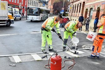 Markneukirchen: Kreuzungsbau beendet - schönes Eingangstor in die Stadt - Punktlandung: Das Team der Maler Süd Chemnitz nahm letzte Markierungen vor, während der Bus bereits auf die Durchfahrt wartet.