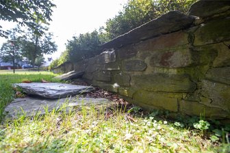 Marode Mauer in Theuma wird ausgebessert - Der einstige Teich in Theuma, ein heutiger Park unterhalb des Kriegerdenkmals, ist mit einer Steinmauer umrandet. Die Abdeckplatten sind locker und zum Teil abgestürzt.