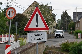 Marode Ortsdurchfahrt in Königshain-Wiederau: Wo Bauarbeiten anstehen - In der Gemeinde Königshain-Wiederau hofft man, dass sich der Zustand der Staatsstraße 247 bald merklich verbessert. An mehreren Stellen, wie hier in Wiederau, weisen Schilder auf Fahrbahnschäden hin.