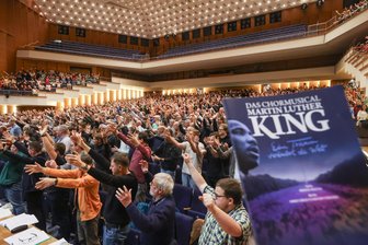 „Martin-Luther-King“-Musical als Kulturhauptstadt-Projekt in Chemnitz: 1500 Laiensänger der Region treten gemeinsam mit Profis auf - Für die Hauptprobe des „Martin-Luther-King“-Musicals am vergangenen Sonntag mieteten die Organisatoren die Stadthalle Chemnitz, um mit allen 1500 Chorsängerinnen und -sängern gemeinsam üben zu können. Zu den zwei Aufführungen in der Messehalle werden aus technischen Gründen jeweils 750 Sängerinnen und Sänger auf der Bühne stehen.