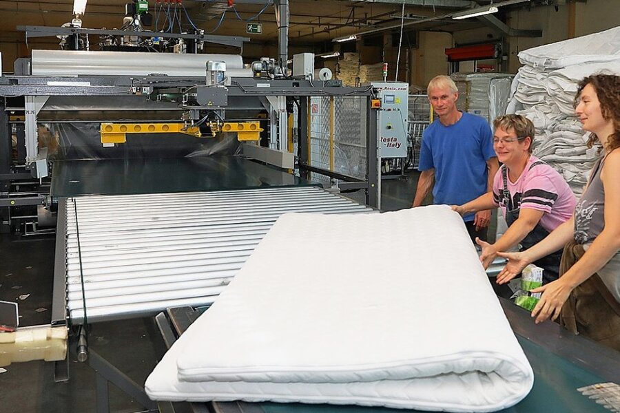 Matratzenhersteller in Langenhessen investiert in Verpackungsmaschine - Lisa Kaczmarek, Anet Altmannshofer und Achmed Barth (von rechts) bestückten die neue Verpackungsmaschine mit einer Matratze.