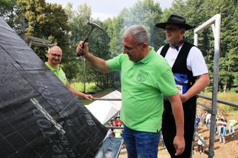 Mechelgrüner feiern Richtfest für Obere Mühle: Wieder ein wichtiger Schritt für Mammutprojekt geschafft - Christian Groth (links) und Udo Pürzel (rechts) schauen René Turczyk auf die Finger beim Einschlagen des vorletzten Nagels.