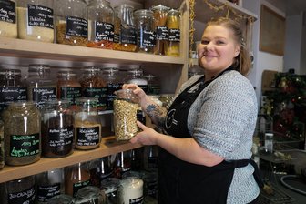 Mehr als Unverpacktes: Wie der Tante-Emma-Laden Kirchberg besteht - Heidi Dörrer-Reuter am Regal mit der unverpackten Ware. Wollen Kunden Getreide und Nudeln, Müslimischungen und Gewürze kaufen, bringen sie eigene Mehrweg-Verpackungen mit. Der Gedanke dahinter: Verpackungsmüll vermeiden.