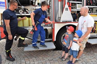 Mehr Angebot als Nachfrage bei Reichenbacher Kinder- und Jugendfest - Faszination Jugendfeuerwehr: Simon erklärt Enrico Fröhlich sowie den Kindern Emil und Kurt, wie ein Strahlrohr funktioniert. Links im Bild Jugendgruppenleiter Ralf Goldhardt.
