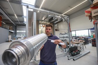 Mehr Fläche für Musterbau: Gebäudetechnik-Firma investiert in Fertigungshalle - Anlagenmechaniker Lennart Kaden fertigt Teile für die Lüftungsanlage eines Musterbades, wie es später in einem Hotel aufgebaut wird.
