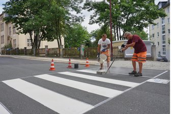 Mehr Sicherheit vor Auerbacher Schulen: Hier gibt es Zebrastreifen - Nico Krehan und Markus Müller bringen vor der Gebrüder-Grimm-Grundschule einen Zebrastreifen auf den Asphalt.