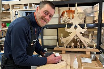 „Mein Telefon stand nicht mehr still“: Holzkünstler aus dem Erzgebirge kommt mit Produktion kaum nach - Mirco Dost hat viel zu tun: Mit Leim befestigt er die einzelnen Teile seiner Fichten.