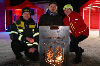 Meisterschaft im Weihnachtsbaum-Weitwurf im Erzgebirge auf Eis gelegt - Beim Knutfest in Oelsnitz – im Bild (v. l.) Alexander Willhelm von der Feuerwehr, Florian Stahl sowie Sieglinde König, Betreuerin bei der Kinderfeuerwehr.