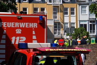 Menschen aus Bank befreit - Was wir wissen und was nicht - Rettungswagen, Polizisten und Polizeifahrzeuge stehen in der Nähe des Einsatzortes.
