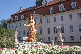 Meterhohe Kürbisfiguren im Schlosspark Lichtenwalde: Zehn Fragen und Antworten zum Kürbisfestival - Eine Meerjungfrau aus Kürbissen, Holz und Drahtgeflecht posiert vor dem Barockschloss in Lichtenwalde.
