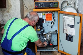 "Mieter brauchen Mitspracherecht beim Heizungstausch" - Ein Monteur kontrolliert eine ältere Heizungsanlage in einem Keller. Wenn die mal ersetzt werden muss, kann es auch für die Mieter teuer werden.