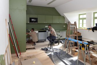 Millionenprojekt im Erzgebirge: Wo eine neue Grundschule erstmals ihre Türen öffnet - Jonathan Mögel (l.) und René Stosschek haben am Mittwoch in der künftigen Grundschule die Kinderküche eingebaut.