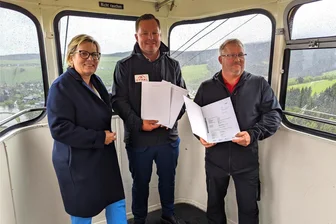 Ministerin erlebt am Fichtelberg Schreckmoment - „Geldübergabe" hoch in der Luft: Tourismusministerin Barbara Klepsch mit Oberwiesenthals stellvertretendem Bürgermeister Erik Schulze und FSB-Chef René Lötzsch (v. l.) in der Fichtelberg-Schwebebahn.