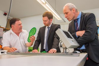 Ministerpräsident besucht Eibenstocker Stickerei - Firmenchef Hartmut Funke (links) erklärt Ministerpräsident Michael Kretschmer und Eibenstocks Bürgermeister Uwe Staab die Funktionsweise der innovativen Sohle.