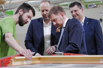 Ministerpräsident Kretschmer besucht Plauener Fensterbaufirma Grünbeck: Einblicke, Sorgen und Perspektiven - Ministerpräsident Michael Kretschmer beim Firmenbesuch im Gespräch mit Schichtleiter Felix Müller.