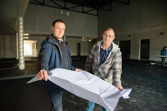 „Mission Weltall“: Macher der neuen Raumfahrtaustellung im Vogtland von Entwürfen begeistert - Ingenieur Sven Seidel (links) vom Architekturbüro Delta Plan und Bernd Trommer vom Bauamt der Gemeinde Muldenhammer schauen sich im künftigen Veranstaltungsraum der Deutschen Raumfahrtausstellung in Morgenröthe-Rautenkranz Pläne zum neuen Anbau an.