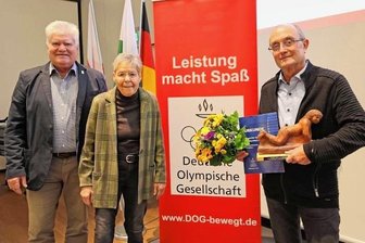 "Mister Triathlon" geehrt - Der Vorsitzende Wolfgang Beuschel (links) und Gabriele Lehmann von der DOG-Stadtgruppe Zwickau überreichten Wolfgang Hertrampf (rechts) den Preis für vorbildliche Sportförderung.