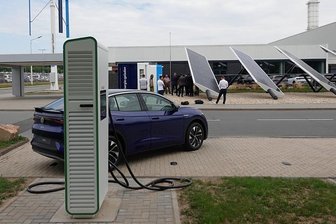 Mit ausgedienten E-Auto-Batterien: VW nimmt Ladepark in Zwickau in Betrieb - Der Schnellladepark im VW-Werk Mosel nebst Solar- und Windkraftanlagen. Im Vordergrund eine von vier Ladesäulen. Hinter dem Fahrzeug ist auf der anderen Straßenseite der Power Storage Container zu sehen. 