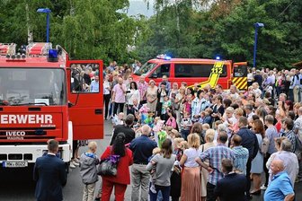 Mit Blaulicht und Sirenen: Feuerwehrleute bringen ABC-Schützen in Rochlitz und Wiederau ihre Zuckertüten - Die Überreichung der Zuckertüten durch Feuerwehrleute, die mit Blaulicht und Sirenen auf den Parkplatz der Regenbogen-Turnhalle fuhren