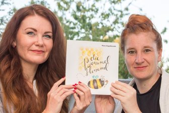 Mit der Bummel-Hummel unterwegs - Katja Fugmann (l.) und Nora Engelbrecht mit dem Kinderbuch "Die Bummelhummel".