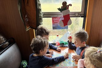 Mit der Fichtelbergbahn auf großer Nikolausfahrt durchs Erzgebirge - Die Kinder hatten sichtlich Spaß bei den verschiedenen integrierten Brettspielen auf den Tischen im Bahnwaggon, während die erzgebirgische Landschaft draußen vorbeizog.